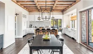  ?? Hikesterso­n / Getty Images ?? In an Instagram-ready home, wood beams and pendant lights accent a kitchen-dining area.