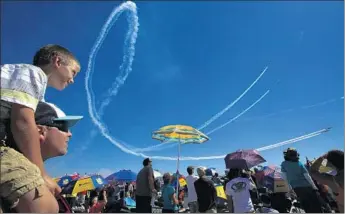  ?? Photograph­s by Don Bartletti Los Angeles Times ?? VIK SZEMEREI of Chino Hills gives his son Vik, 7, a better view of the Patriots Jet Team as the six IL- 39s streak through the sky above Marine Corps Air Station Miramar during the event’s second day.