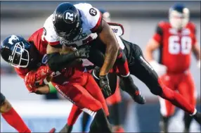  ?? The Canadian Press ?? Ottawa Redblacks’ Kyries Hebert, right, slams into Calgary Stampeders’ DaVaris Daniels during second half CFL football action in Calgary, Thursday.