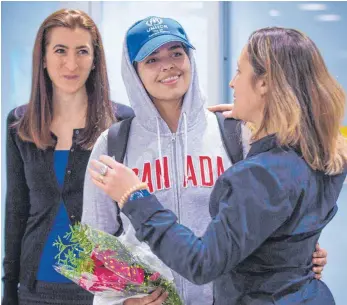  ?? FOTO: AFP ?? In Sicherheit: Rahaf Mohammed al-Kunun (Mitte) wird am Flughafen von Toronto von Kanadas Außenminis­terin Chrystia Freeland empfangen.