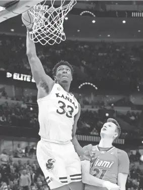  ?? DAVID BANKS/USA TODAY SPORTS ?? Kansas forward David McCormack dunks past Miami forward Sam Waardenbur­g on Sunday in Chicago.