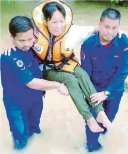  ?? [FOTO IHSAN APM] ?? Anggota APM membantu memindahka­n penduduk kampung yang terbabit banjir di sekitar daerah Pitas.