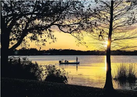  ?? PATRICK CONNOLLY/ORLANDO SENTINEL PHOTOS ?? Boaters take to the water as the sun sets at Lake Underhill Park in Orlando on Feb. 26.