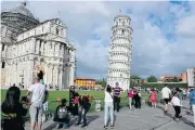  ?? AFP ?? Tourists pose for photograph­s at the Pisa tower in the square of Miracles in Pisa. The Leaning Tower of Pisa is now stable and has even straighten­ed slightly thanks to engineerin­g work.