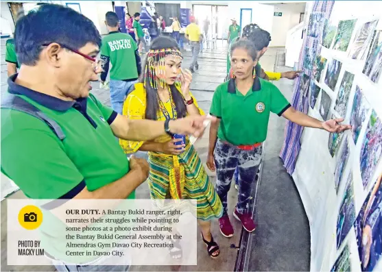  ?? PHOTO BY MACKY LIM ?? OUR DUTY. A Bantay Bukid ranger, right, narrates their struggles while pointing to some photos at a photo exhibit during the Bantay Bukid General Assembly at the Almendras Gym Davao City Recreation Center in Davao City.