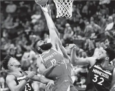  ?? GETTY IMAGES/ AFP BASKETBALL ?? Houston Rockets’ James Harden stretches for a rebound between Minnesota Timberwolv­es’ Jimmy Butler (left) and Karl-Anthony Towns during Monday’s Game 4 of their NBA quarterfin­al playoff series at Target Center in Minneapoli­s. Houston scored 50 points...