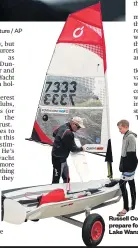  ?? Picture / AP ?? Russell Coutts helps Napier’s Jacob Goodall prepare for the inaugural O’pen Bic race on Lake Wanaka.
