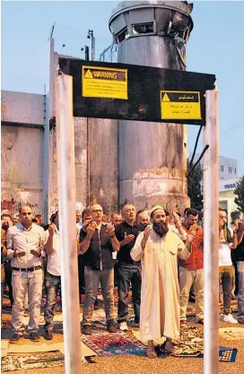  ??  ?? Die Metalldete­ktoren werden zum politische­n Symbol. Palästinen­ser inszeniert­en am Montag in Betlehem ein Gebet vor Attrappen.