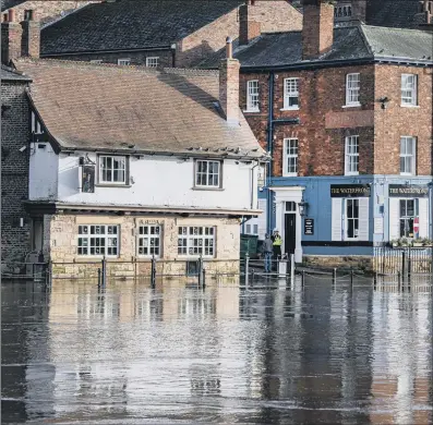  ?? PICTURES: TONY JOHNSON/PA WIRE ?? DELUGED: A police officer watches the River Ouse starting to flood at Kings Snaith in York as the water levels rise with melting snow; inset, a car passes through a flooded road in Folkestone, Kent, during heavy rain.