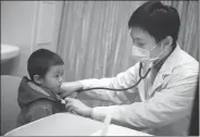  ?? ZHANG ZIWANG / FOR CHINA DAILY ?? Pediatrici­an Yang Yang checks a child at Guangzhou Women and Children’s Medical Center in Guangdong province in January.