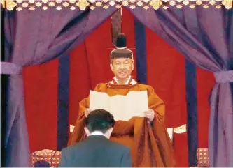  ?? AP-Yonhap ?? Emperor Naruhito speaks as Japan’s Prime Minister Shinzo Abe bows during a ceremony to proclaim his enthroneme­nt to the world, called Sokuirei-Seidenno-gi, at the Imperial Palace in Tokyo, Japan, Tuesday.