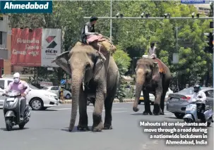  ??  ?? Mahouts sit on elephants and move through a road during a nationwide lockdown in
Ahmedabad, India