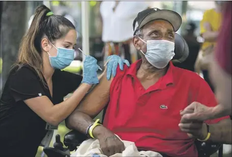  ?? GARY RUCKER Jason Armond Los Angeles Times ?? receives a dose of COVID-19 vaccine at a vaccinatio­n clinic in the skid row neighborho­od of downtown Los Angeles.