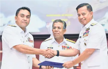  ??  ?? Mohd Reza (left) hands over duty to Mohamad Adib (right) witnessed by Mohamad Roslan. — Bernama photo