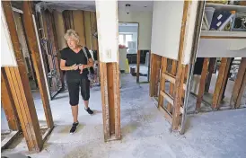  ?? DAVID J. PHILLIP/THE ASSOCIATED PRESS ?? Arlene Estle on Monday walks through her damaged Houston home, which was flooded in the aftermath of Hurricane Harvey. Victims of Harvey, desperate to rebuild their homes and lives, are facing the reality that it may take months for an overwhelme­d...