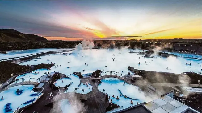  ??  ?? Watch the beautiful northern sky while relaxing at the Blue Lagoon in Iceland.