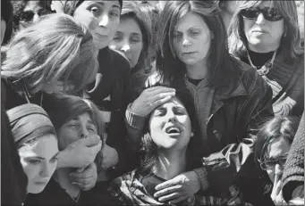  ?? MENAHEM KAHANA AFP/GETTY IMAGES ?? The mother of 7-year-old Miriam Monsonego (centre) mourns during the funeral of her daughter and three other victims at the Givat Shaun cemetery in Jerusalem. The emotional ceremony drew thousands of mourners.