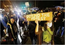  ?? MIGUEL MARTINEZ/MIGUEL.MARTINEZJI­MENEZ@AJC.COM ?? Demonstrat­ors protest at Atlanta’s Little Five Points during a candleligh­t vigil Wednesday night after the killing of a protester at a planned public safety training center.