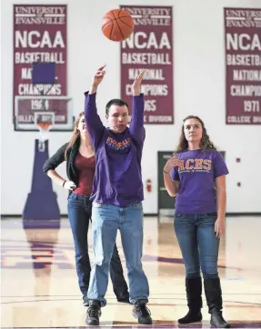  ?? 2013 PHOTO BY MATT DETRICH/THE INDIANAPOL­IS STAR ?? Bryce Weiler, a blind manager for Evansville’s men’s basketball team, demonstrat­es how he shoots free throws with help from friend Janelle Gore, right.