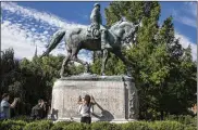  ?? EDU BAYER / THE NEW YORK TIMES ?? The statue of Robert E. Lee in Charlottes­ville, Va. The granite pedestal supporting the statue at the center of the story was made in Washington by the Toledobase­d company Lloyd Brothers. Historian Becky Visser of Perrysburg recognized the Toledo tie...