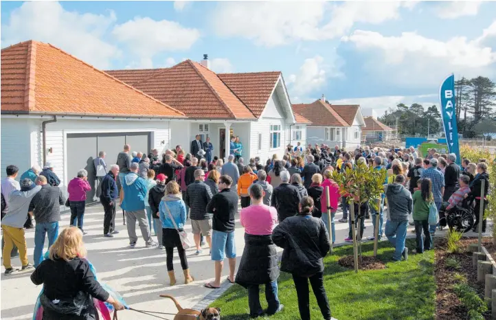  ??  ?? A typical scene during the housing boom in Auckland: potential buyers flock to an on-site auction at Hobsonvill­e Pt, a developmen­t on what was Whenuapai air force land.