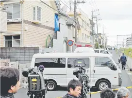  ??  ?? Journalist­s and TV camerapers­ons beside an apartment (partialy covered with a blue sheet) where Japanese police found the bodies. — AFP photo