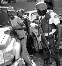  ?? AP ?? A policeman detains a commuter at a checkpoint in downtown Port-au-Prince, Haiti, on Thursday.