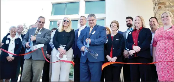  ?? TIMES photograph by Annette Beard ?? Mayor Jackie Crabtree, left, and Dr. Matthew Jennings, right, cut the ribbon during the ceremony Wednesday signifying the opening of the new Mercy Clinic in Pea Ridge. Lisa Crowder, center, and her father, Kent Webb, were recognized as the lab is...