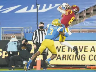  ?? Ashley Landis / Associated Press ?? USC’s AmonRa St. Brown hauls in a touchdown pass against UCLA last weekend. The Trojans will be looking to soar past Oregon in the Pac12 championsh­ip game on Friday night.