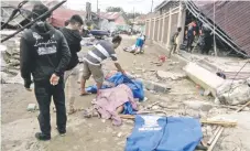  ??  ?? Residentes de Palu buscaban a sus familiares entre los cuerpos que quedaron esparcidos en la zona y que fueron cubiertos con plásticos o sábanas.