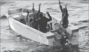  ?? — GETTY IMAGES ?? A group of pirates keep their arms raised aboard a skiff after a Spanish naval ship’s protection team captured them.