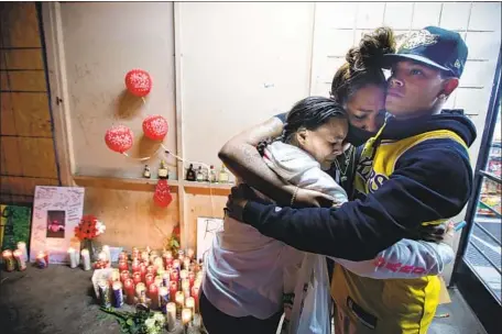  ?? THREE COUSINS Jason Armond Los Angeles Times ?? of Mark Matthew Bender Jr. — from left, Christina Ray, Monica Terrell and Christophe­r Kelly — gather Friday at a makeshift memorial in front of King Tut Liquor in San Bernardino. Bender was fatally shot there Thursday night by a police off icer.