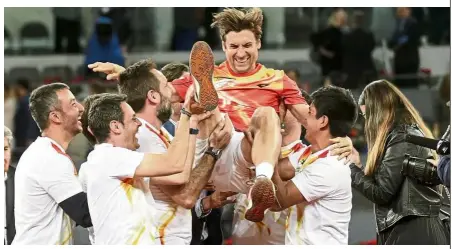  ?? — AP ?? You’ll be missed: David Ferrer of Spain is lifted up by friends during a ceremony for his retirement as a profession­al tennis player during the Madrid Open on Wednesday.