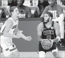  ?? MIKE EHRMANN/GETTY ?? Celtics’ Jayson Tatum drives the ball against the Heat’s Kelly Olynyk in Game 5 of the Eastern Conference finals on Friday in Lake Buena Vista, Florida.