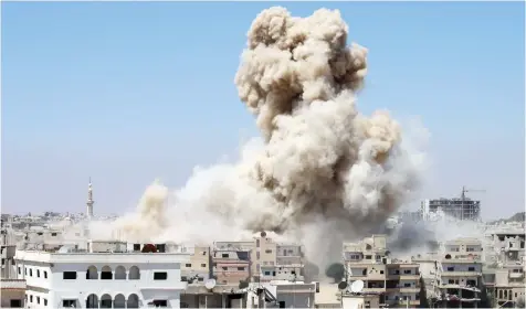  ??  ?? Smoke rises from buildings following a reported airstrike on an opposition-held area in the southern Syrian city of Daraa, on Wedensday. (AFP)