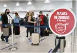  ?? Joe Raedle/Getty Images/TNS ?? ■ A sign stating “Masks required in this area” is seen as travelers prepare to check-in for their Delta airlines flight at Miami Internatio­nal Airport on Feb. 1 in Miami.