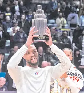 ?? AP PHOTO/DARRON CUMMINGS ?? NBA ALLSTAR MVP. Milwaukee Bucks guard Damian Lillard (0) lifts the MVP trophy after the East defeated the West 211186 in the NBA All-Star basketball game in Indianapol­is, Sunday, Feb. 18, 2024.