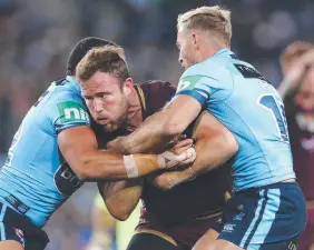  ??  ?? BRAVE: Gavin Cooper of the Maroons cops some heavy NSW defence.