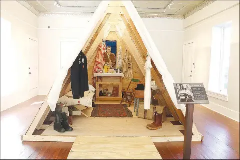  ?? (NWA Democrat-Gazette/Lynn Kutter) ?? This wooden tent is a replica of the temporary shelters constructe­d for Resurrecti­on City and the 1968 Poor People’s Campaign in Washington, D.C. Lawrence McElroy, director of arts and culture for Historic Cane Hill, used the photo in the foreground to replicate what the inside of a tent would have looked like at Resurrecti­on City, a 43day campaign in 1968 to bring attention to the plight of poverty.