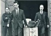  ??  ?? Milner, centre, carrying a box of evidence; as ‘exhibits officer’ he assembled some 2,000 items