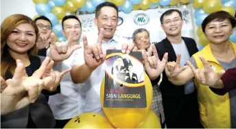  ??  ?? See (centre) using sign language in launching the book.