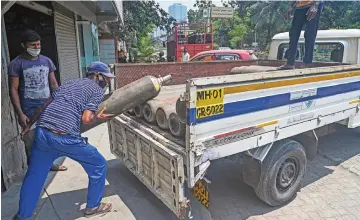  ?? (AFP) ?? Workers load oxygen cylinders for hospital use as the COVID-19 cases rise in India, in the western city of Mumbai on Sunday