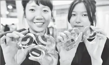  ??  ?? Man-lin (left) and Chieh-ying display Chinese character stamps during an exhibition in Taipei.