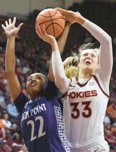  ?? MATT GENTRY/THE ROANOKE TIMES ?? Virginia Tech’s Elizabeth Kitley goes to score past High Point’s Shakira Baskervill­e during the first half of Monday night’s season opener at Cassell Coliseum in Blacksburg.