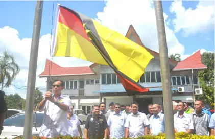  ??  ?? Jamit raises the Sarawak flag during the event.