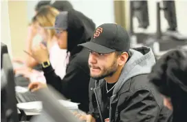  ?? ANDA CHU/STAFF ?? Marvin Pimentel, center, of South San Francisco, works on a research paper during his English 105 class at Skyline College in San Bruno.