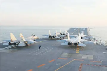  ??  ?? Photo shows Chinese J-15 fighter jets waiting on the deck of the Liaoning aircraft carrier during military drills in the Bohai Sea, off China’s northeast coast. — AFP photo