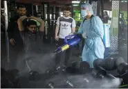  ?? ASSOCIATED PRESS FILE PHOTO ?? A Palestinia­n health worker sprays disinfecta­nt as a precaution against the virus in a gymnasium in Gaza City.