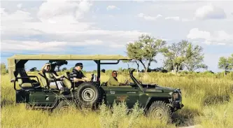  ?? PHOTOS: GETTY IMAGES ?? Searching . . . Tourists and driver sitting in a Land Cruiser jeep are looking for game.