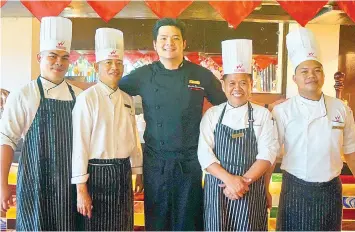  ??  ?? Executive Chef Tristan Encarnacio­n (in black), with the hotel’s culinary team